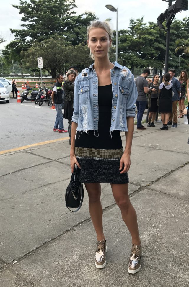 Modelo Renata Kuerten no SPFW com vestido, jaqueta jeans e tênis