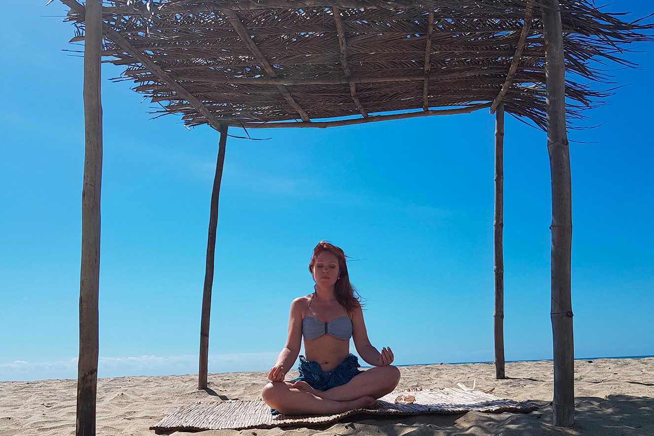 Cacá Filippini meditando na praia