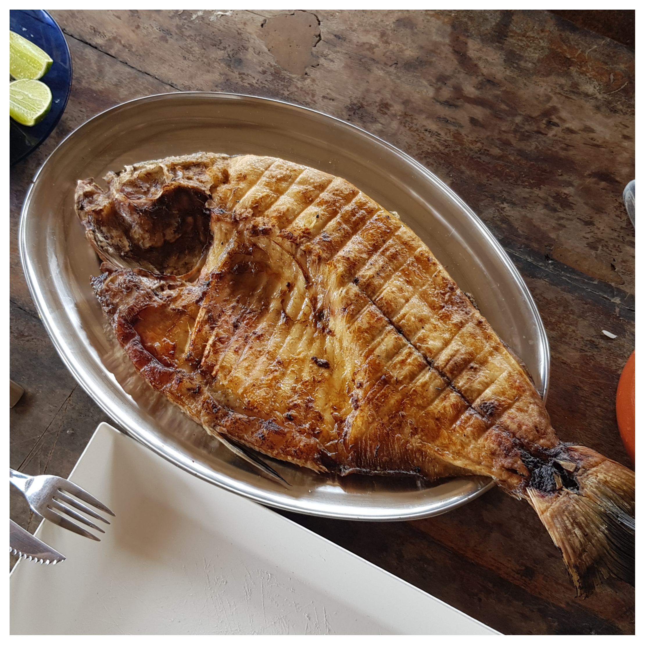 Peixe tambaqui assado servido na mesa de madeira