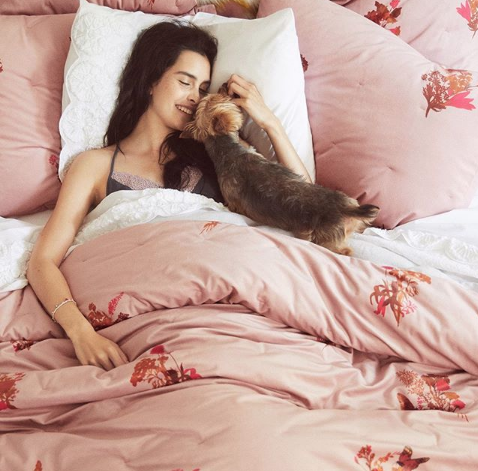 mulher dormindo em cama confortável com seu cachorrinho