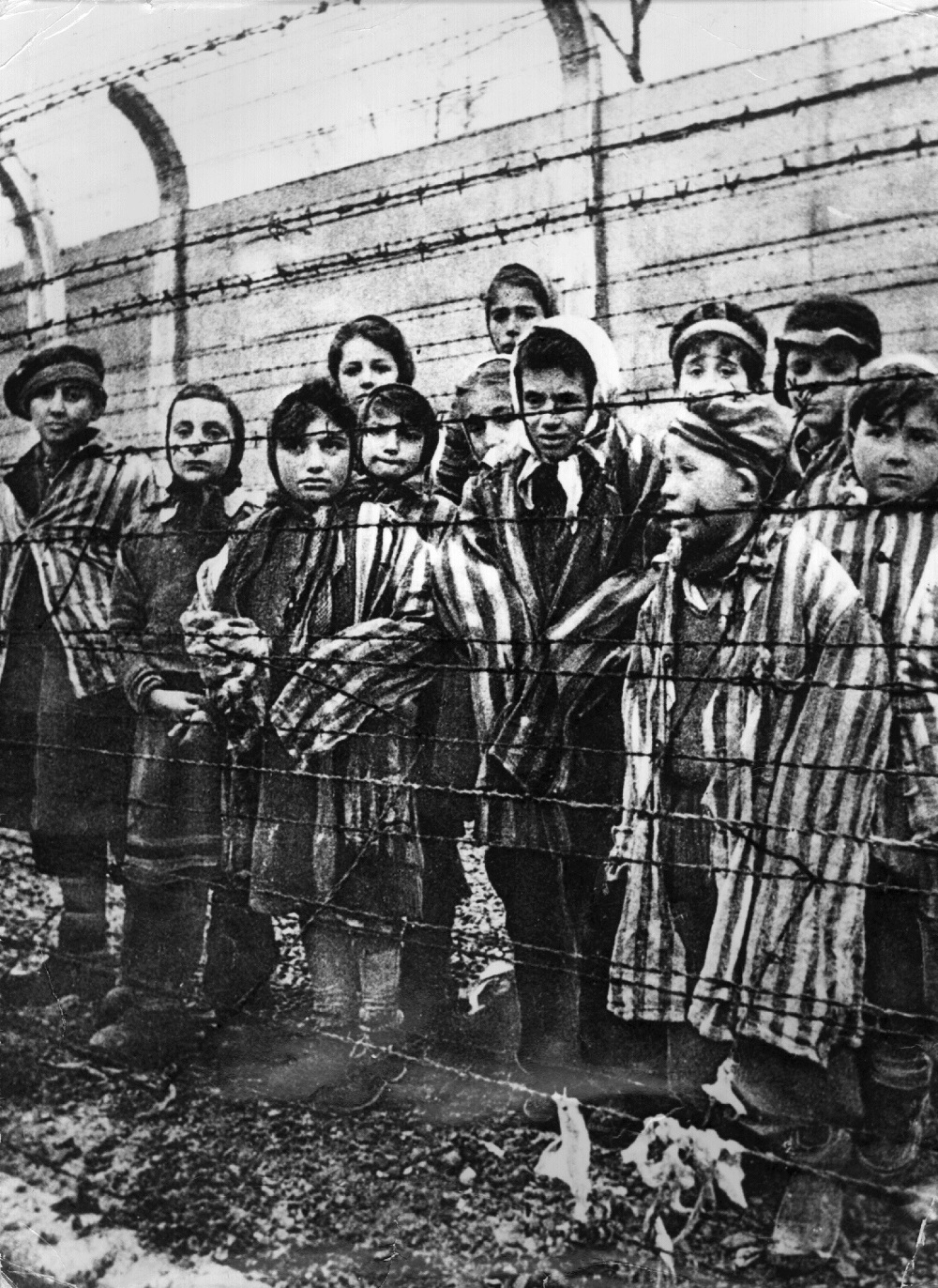 Crianças atrás de uma cerca de arame farpado no campo de concentração nazista de Auschwitz no sul da Polônia. (Foto: Keystone/Getty Images)