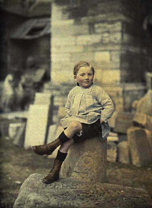 Menino sentado em uma pedra, provavelmente um depósito da catedral, na França, em 1º de abril de 1917. (foto: worldwaronecolorphotos.com)