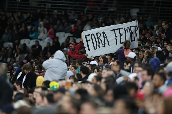 Faixa de protesto contra o presidente interino Michel Temer é exibida durante o jogo de futebol feminino entre Canadá e França, na Arena Corinthians, pela Rio 2016 (Alexandre Schneider/Getty Images)