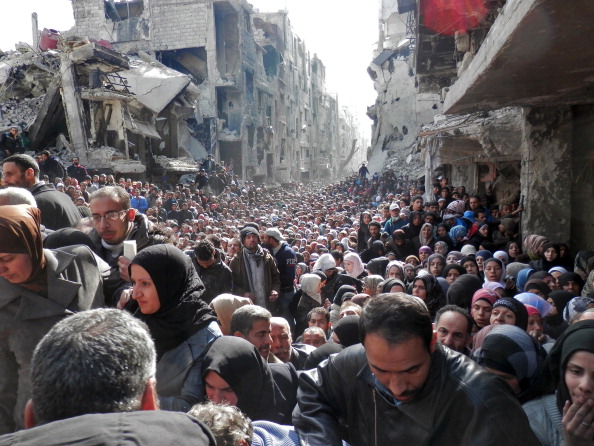 Centenas de pessoas esperam a chegada da ajuda humanitária da ONU para receber comida em Damasco: Guerra civil na Síria já matou cerca de meio milhão de pessoas (foto: Getty Images)