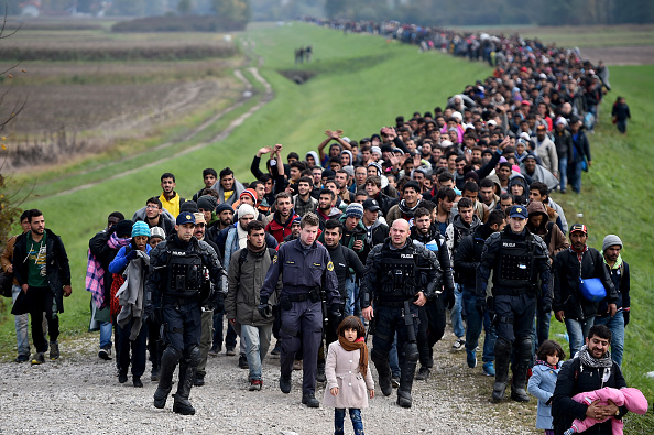 Imigrantes do Oriente Médio são escoltados pela polícia na Slovenia, em outubro de 2015 (foto: Jeff J Mitchell/Getty Images)