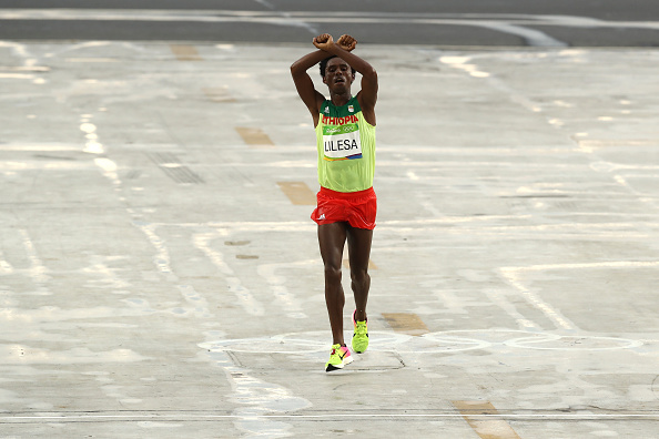O corredor Feyisa Lilesa da Etiópia protesta com os braços cruzados na chegada da maratona na Rio 2016 (Buda Mendes/Getty Images)
