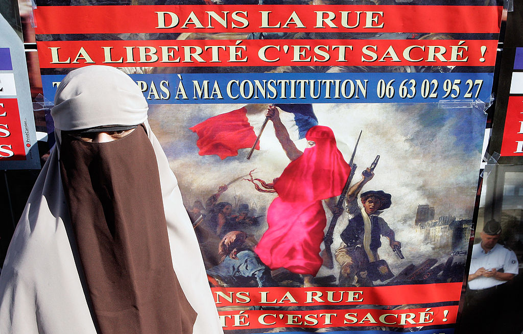 <b id="message-undefined" class="error-message">Imagem sem texto alternativo</b> Mulher protesta em Paris, na França, contra a proibição do uso do niqab (tipo de véu islâmico que deixa visíveis apenas os olhos), em 2011. O cartaz diz “na rua a liberdade é sagrada”