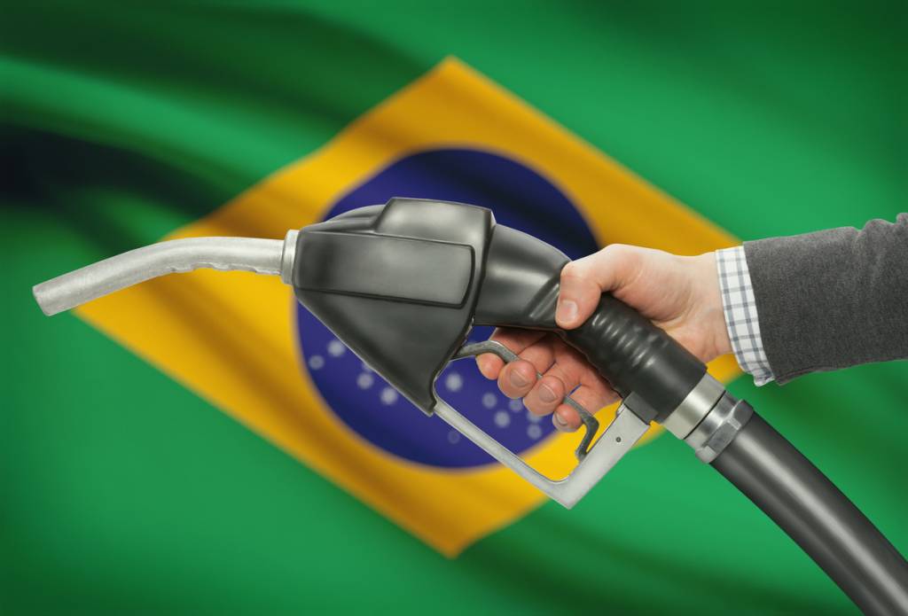 Bomba de gasolina com bandeira do Brasil ao fundo